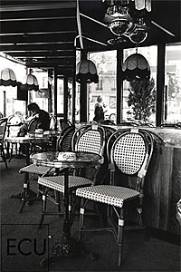 Black and White photo of the historic Caf&eacute; La Rotonde and brasserie with chairs facing the Boulevard Montparnasse in Paris, France