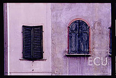 Color photo of a colorful wall and windows in the mountain village of Belluno in the Veneto, Italy